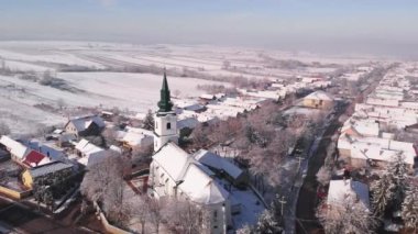 Kış mevsiminde Transilvanya, Romanya, Avrupa ve Yörünge 'de insanların olmadığı küçük bir köyde, Kalvinist ıslah edilmiş bir kilisenin havadan 4k görüntüsü