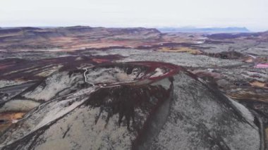 İzlanda, Avrupa 'da tatildeyken muhteşem bir volkan kraterinin tepesinde duran bir çiftin 4k görüntüsü geriye doğru uçan insansız hava aracı,
