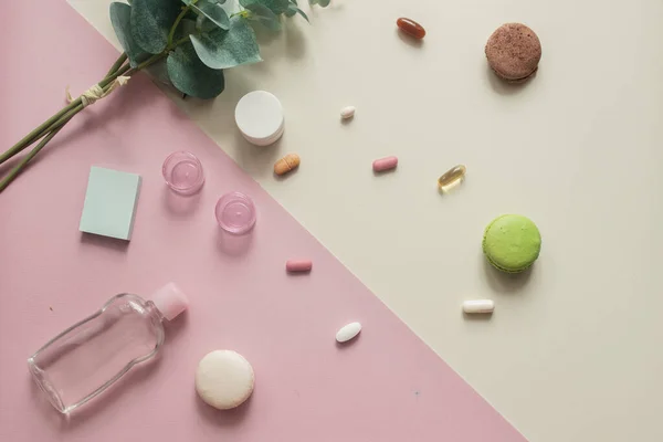 A close-up top view of various pills and macaronis on pink and yellow background. Medical, pharmacy and health care concept. Copy place for text or logo. Dietary supplements and vitamins. Top view