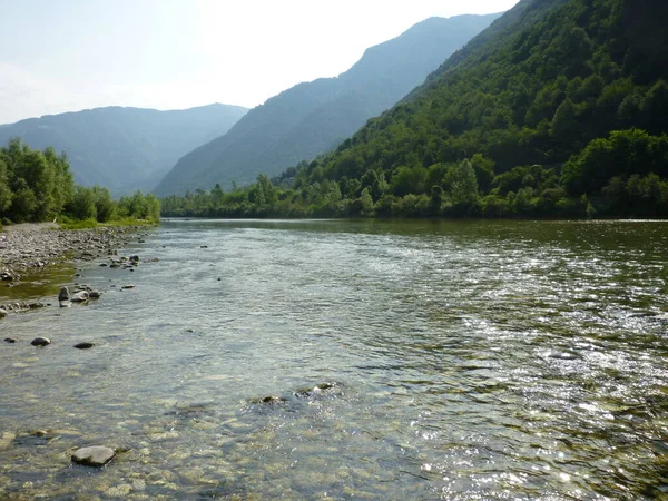 A body of water with a mountain in the background