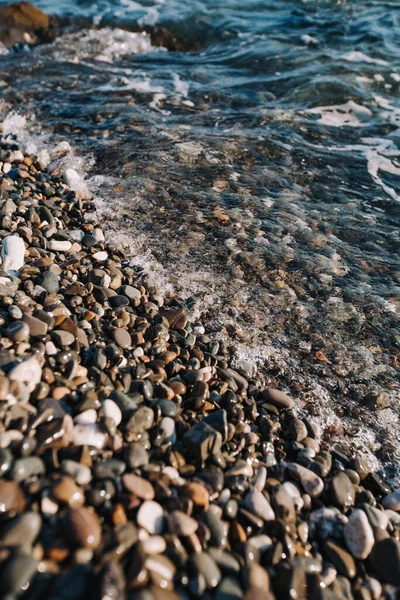 Mavi deniz, çakıl taşlı kıyıları yıkıyor..