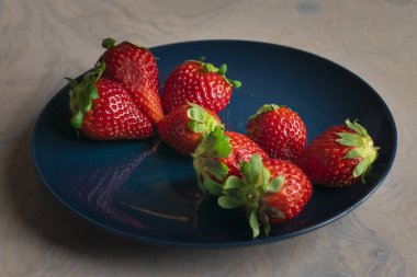 Sağlıklı yemek için yemek masasında çilekli meyve tabağı.