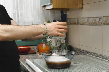 Pasta pişirmek için kase içinde un toplayan genç bir erkek tencere. Kendi kendini pişirecek çöl ya da kahvaltı