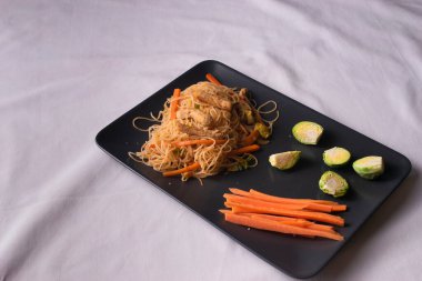 Sağlıklı sebzeli tepsi erişte, tavuk ve sebzeyle tava pişiriyor. Çin yemeği tarifi.