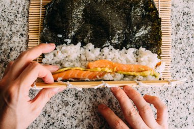 Somon, avokado, pirinç ve yosunlu maki suşi tabağı. Japon yemeği pişirmek. Üst Görünüm.