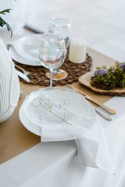 Paskalya bayramı zarif ev dekorasyonu geleneksel bayram yemeği için dekore edilmiş masa bahar çiçekleri, Paskalya dekoru, beyaz peçeteler ve yumurtalarla süslenmiş.