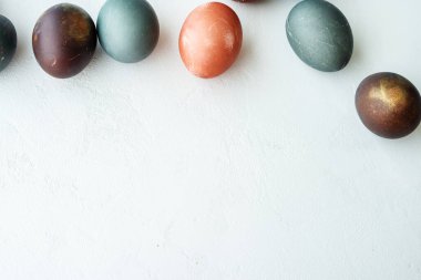Beyaz taş arka planda boyanmış yumurta koleksiyonu, fotokopi alanı, mutlu paskalya konsepti. Doğal renkli yumurta, pastel doğal renk. Boşluğu kopyala, tebrik kartı