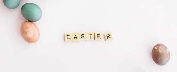Word Easter Written Scrubble Letters Isolated Pink Background Painted Eggs — Stock Photo, Image