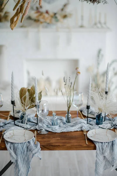 ドライフラワーのおしゃれなテーブルセッティング ヴィンテージの黄金のフォークとナイフ キャンドル 木製のテーブルの上にほこりの多い青いナプキンとプレート 冬の結婚式 — ストック写真