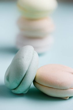 Renkli tatlı zephyr şekerlemeleri. Mavi arka planda hava renkli zephyr, pastel renkler. Yakın çekim, yemek fotoğrafçılığı