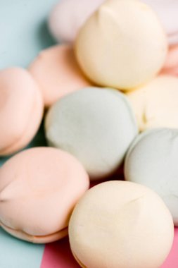 Beyaz arka planda renkli tatlı zephyr şekerlemeleri. Pastel gölgelerde hava şekerlemesi. Kapat.