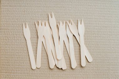 Tek kullanımlık plastik çatallar için alternatif olarak çevre dostu biyolojik çözünürlüklü ahşap çatallar zanaat arka planında görülür