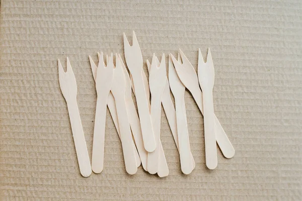 Tek kullanımlık plastik çatallar için alternatif olarak çevre dostu biyolojik çözünürlüklü ahşap çatallar zanaat arka planında görülür