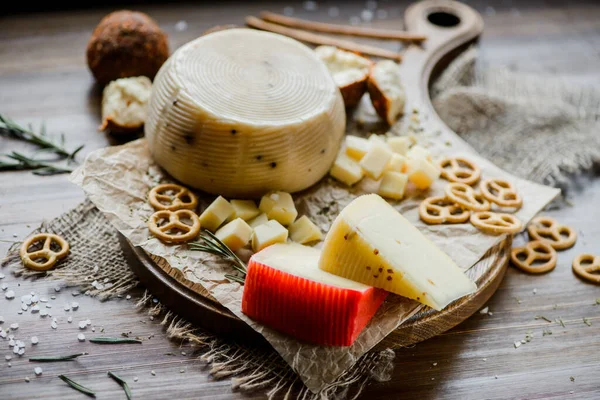 木製の板の上にプレッツェルでハードチーズを盛り合わせました 選択的焦点 — ストック写真