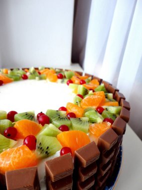 Meyve ve çikolatayla süslenmiş sünger keki.