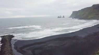 Siyah bir kumsal, uçurumlar ve İzlanda 'daki denizin insansız hava aracı görüntüleri.