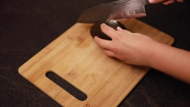 Vrouwenhanden Snijden Een Rijpe Avocado — Stockvideo