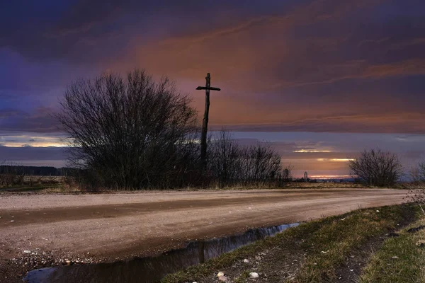 Mountain dirt road, cross beside the road — Stock Photo, Image