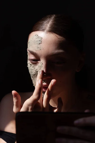 女性の顔に自然な抽出物と有機化粧品マスク スクラブ 黒の背景 — ストック写真