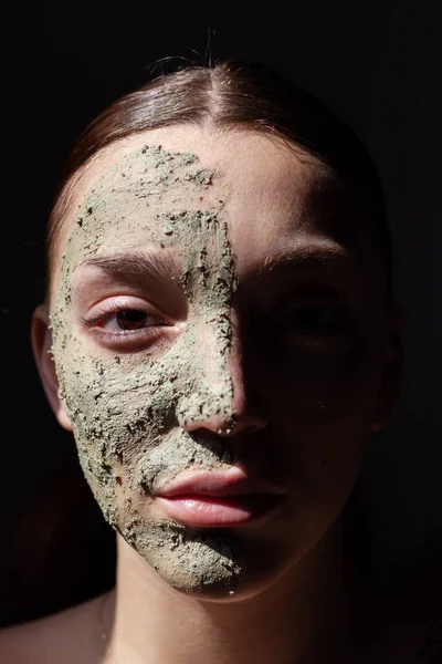 女性は有機化粧緑のマスクで顔 黒の背景 — ストック写真