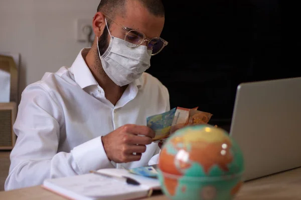 Man with face mask doing his accounting, financial adviser working