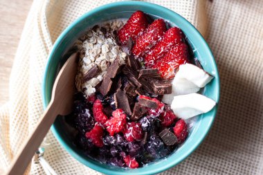 Sağlıklı meyve suyu kasesi granola, taze çilek, yabanmersini, hindistan cevizi, yoğurt ve chia çekirdeği. Sağlıklı yemek, atıştırmalık ya da kahvaltı.