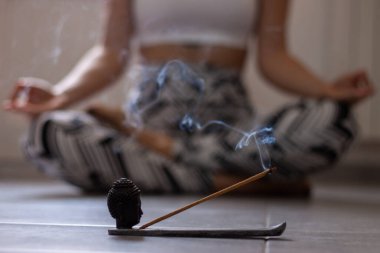 Evde uyandıktan sonra sabah yogası yapan güzel bir kadın görüntüsü. Dişi model bacak bacak üstüne atarak oturuyor. Kolay poz, Sukhasana duruşu ve meditasyon..