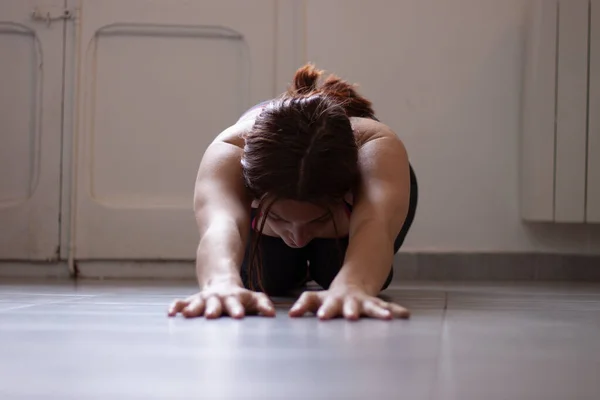 Evde yoga sınıfında poz veren bir kadın.