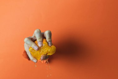 El ele tutuşup portakal sıkmak. Turuncu arkaplan