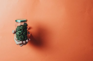 Turuncu arka planda otla el ele tutuşma kavanozu