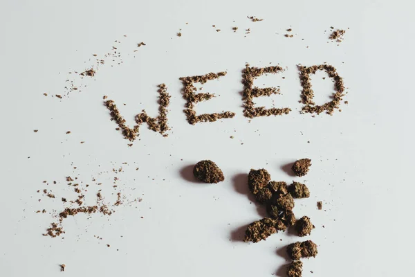 Слово Weed Написано Марихуаной Почки Листья Рассеяния Белом Фоне — стоковое фото