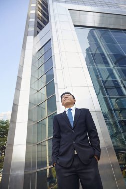 Şirketinin önünde duran bir iş adamı.