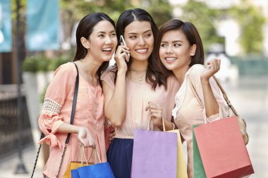 Yanında arkadaşlarıyla telefonda konuşan genç bir kadın.