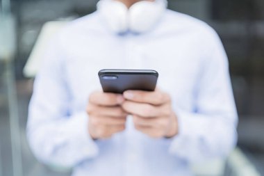Telefonunu kullanan adam.