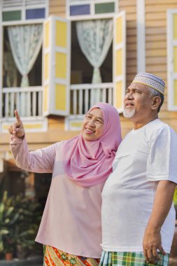 Ahşap evin önünde kıdemli bir çift.