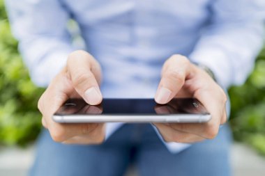 Dışarıda cep telefonu kullanan bir adam.