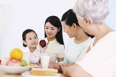 Üç kadın ve bir kız birlikte kahvaltı ediyorlar.