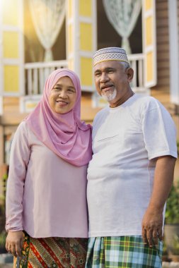 Ahşap evin önünde kıdemli bir çift.