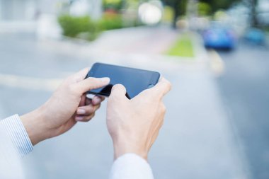 Cep telefonunda oyun oynayan adam