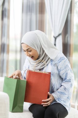 Kadın hediye çantalarını kontrol ediyor.