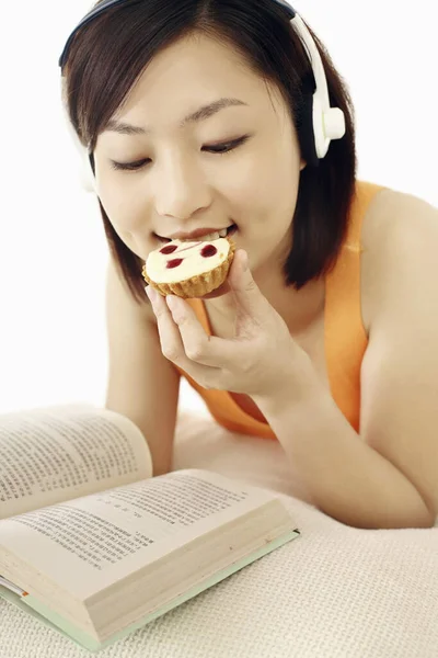 Femme Appréciant Musique Tout Lisant Livre Mangeant Tarte Fromage Aux — Photo