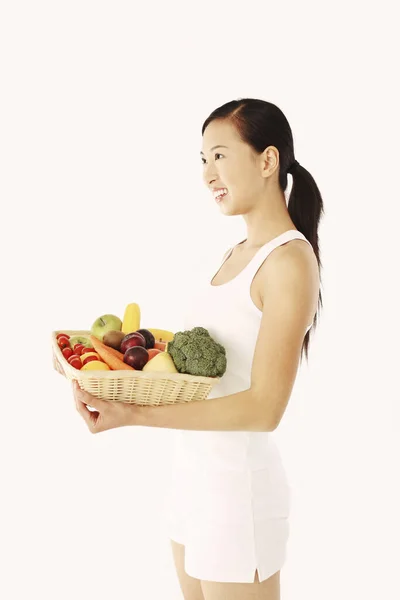 果物や野菜のバスケットを持っている女性 — ストック写真