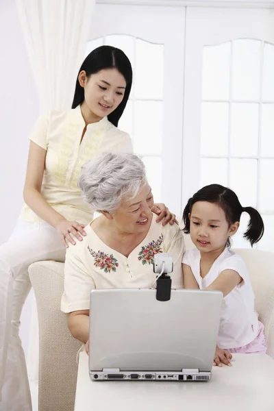 Senior Kvinna Som Använder Laptop Medan Kvinna Och Flicka Tittar — Stockfoto