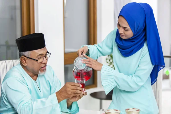 両親に飲料を出すイスラム教徒の女性 — ストック写真