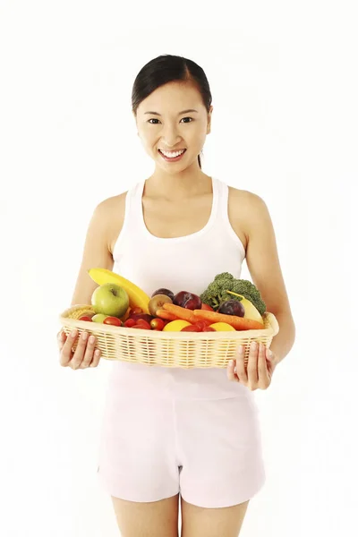 果物や野菜のバスケットを持っている女性 — ストック写真