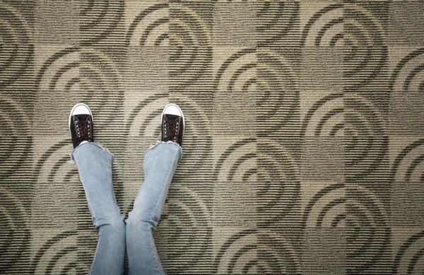 カーペットの床にジーンズと靴を着た女性 — ストック写真