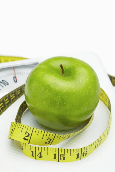 Afgewikkelde Meetlint Rond Een Groene Appel Weegschaal — Stockfoto