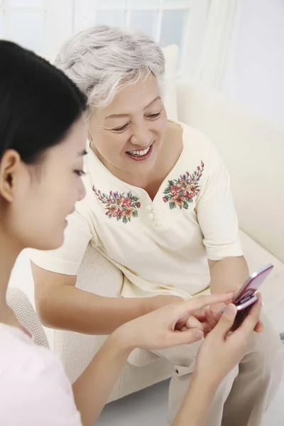Vrouw Toont Senior Vrouw Sms Bericht Aan Telefoon — Stockfoto
