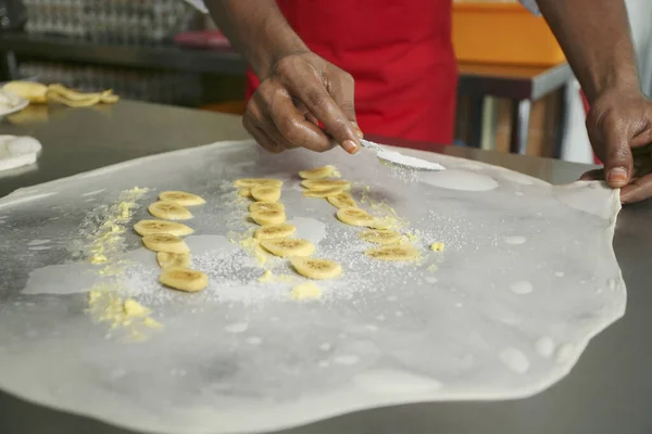 男はフラット生地とバナナスライスに砂糖を振りかける ロティ ピザングを作る — ストック写真