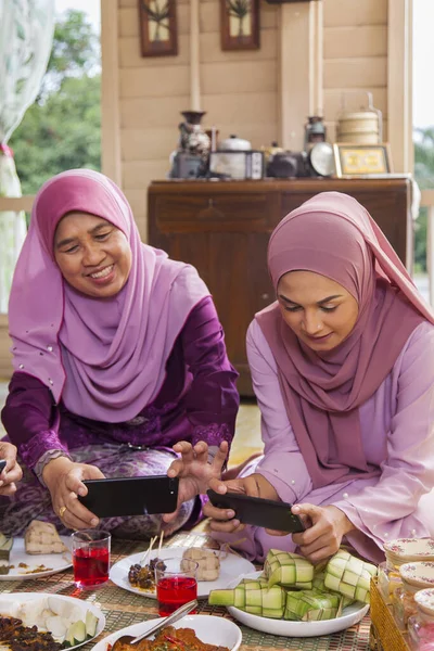 イード フィトルの間に食べ物の写真を撮るイスラム教徒の女性 — ストック写真